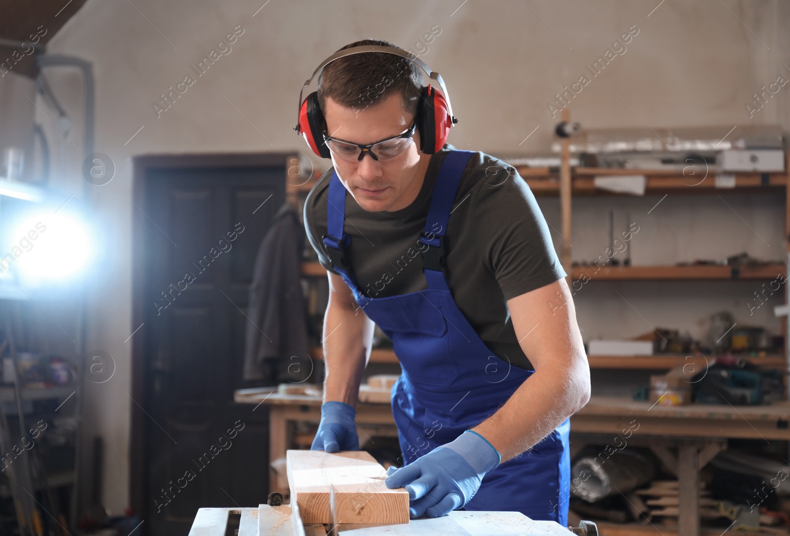 Photo of Professional carpenter working with wood in shop