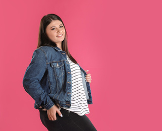Beautiful overweight woman posing on pink background. Plus size model