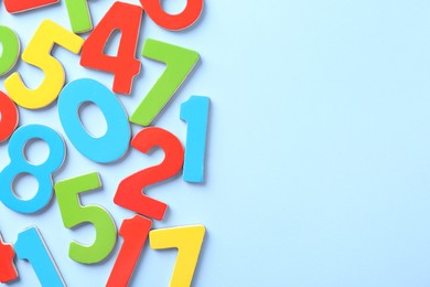 Colorful numbers on light blue background, flat lay. Space for text