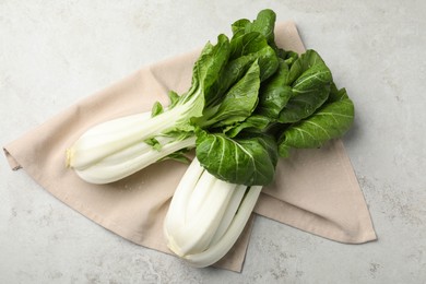 Photo of Fresh green pak choy cabbages with water drops on light grey table, flat lay