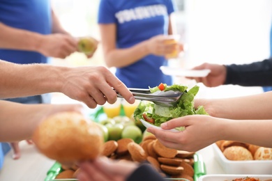 Volunteers serving food to poor people, closeup