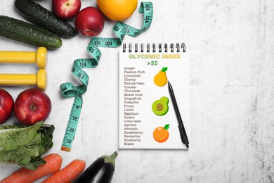 Glycemic index. Information about grouping of products under their GI in notebook, measuring tape, fruits, vegetables and dumbbells on white textured table, flat lay