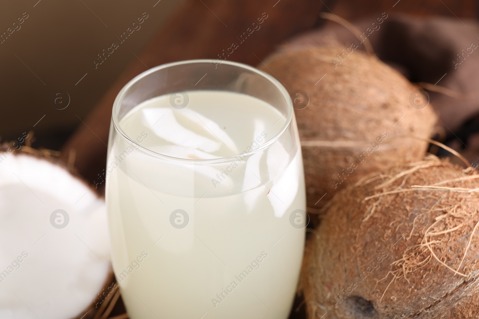 Photo of Glass of coconut water and nuts on table, closeup