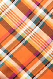 Photo of Checkered fabric with orange color as background, top view