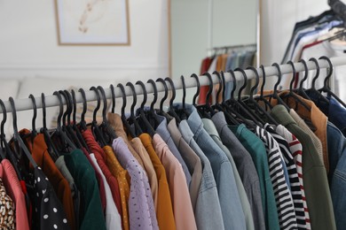 Rack with stylish clothes indoors, closeup. Fast fashion