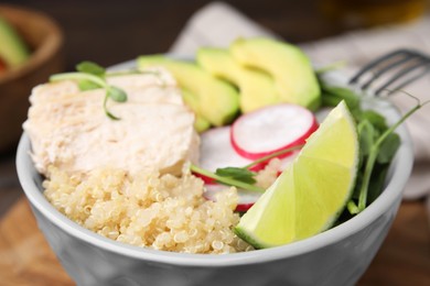 Delicious quinoa salad with chicken, avocado and radish in bowl, closeup