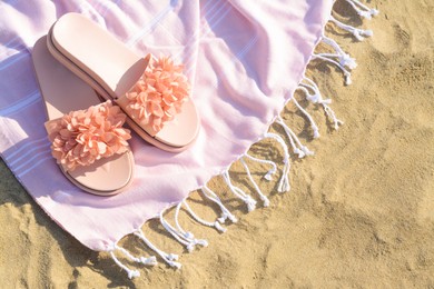 Photo of Blanket with stylish slippers on sandy beach, flat lay. Space for text