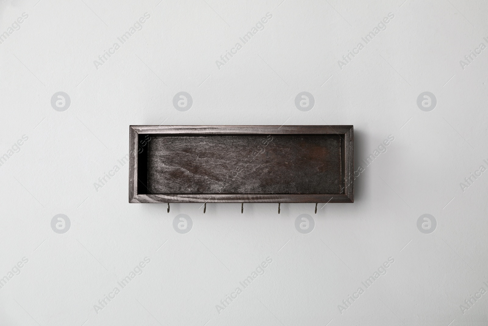 Photo of Wooden hanger for keys on light grey wall