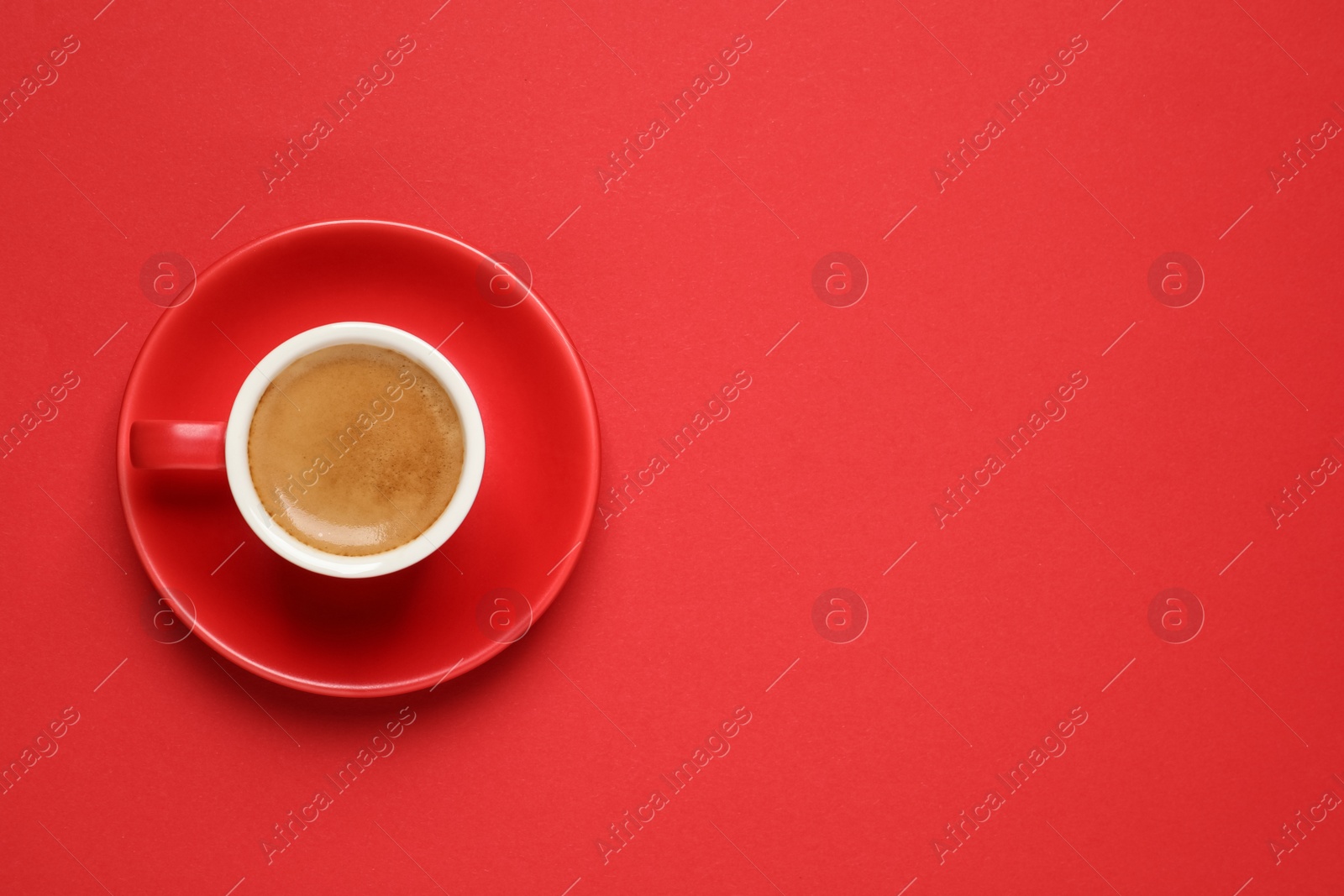 Photo of Cup of aromatic coffee on red background, top view. Space for text