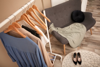 Photo of Wardrobe rack with female clothes in stylish dressing room