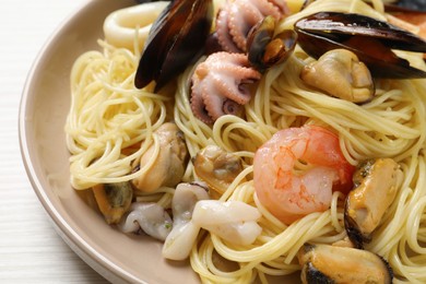 Photo of Delicious pasta with sea food on white wooden table, closeup