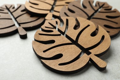 Photo of Leaf shaped wooden cup coasters on white table, closeup