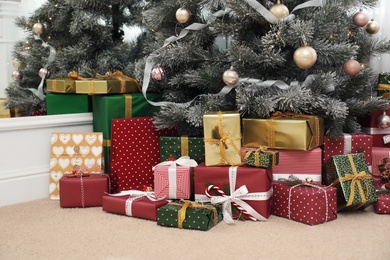 Photo of Many different gifts under Christmas tree indoors