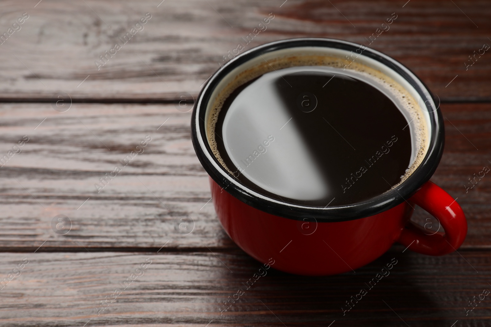 Photo of Cup of aromatic coffee on wooden table, closeup. Space for text