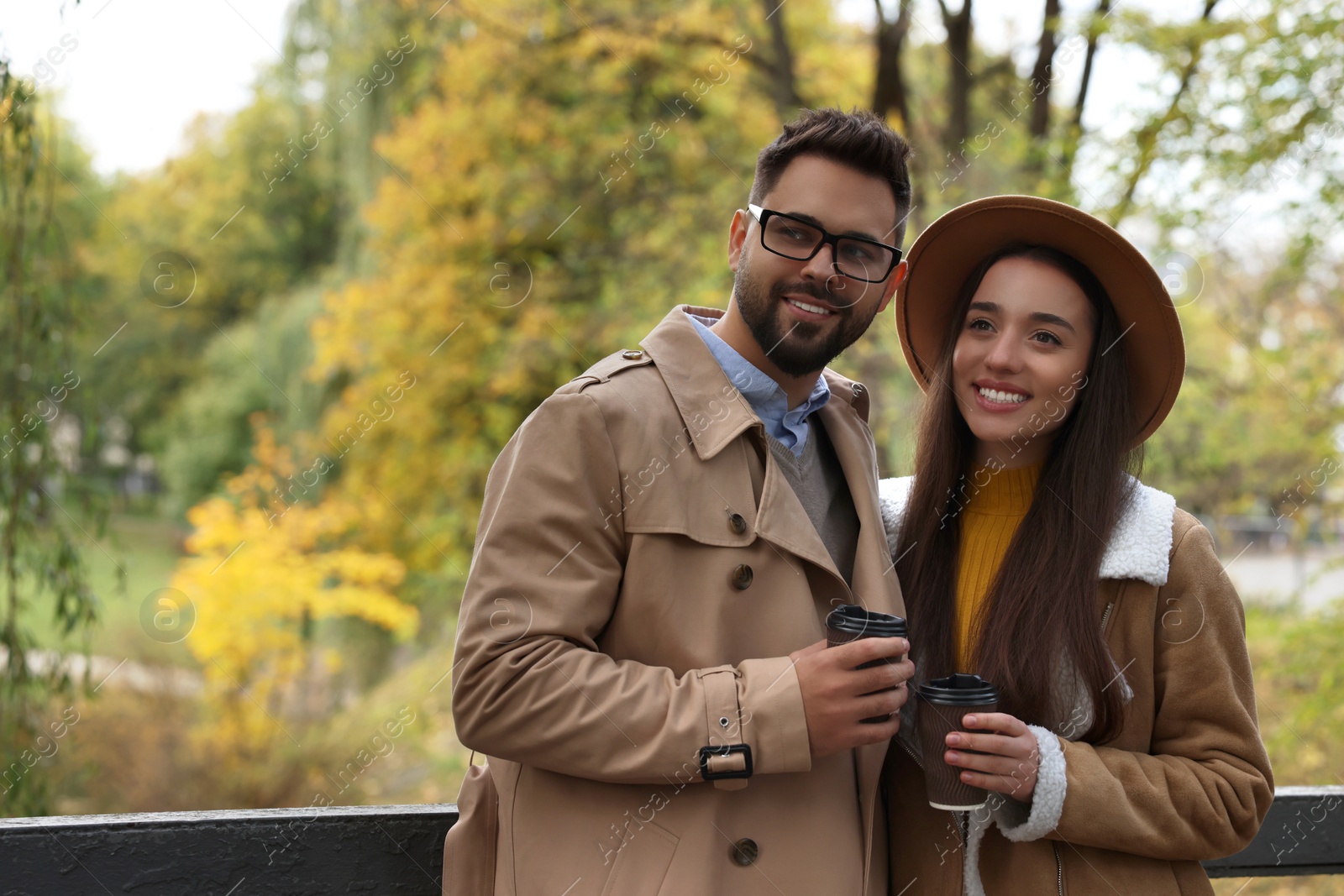 Photo of Romantic young couple spending time together in autumn park, space for text