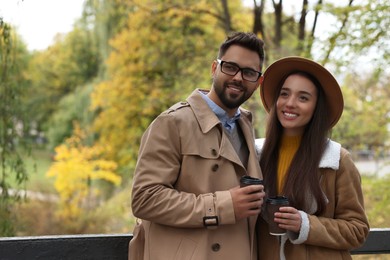 Photo of Romantic young couple spending time together in autumn park, space for text