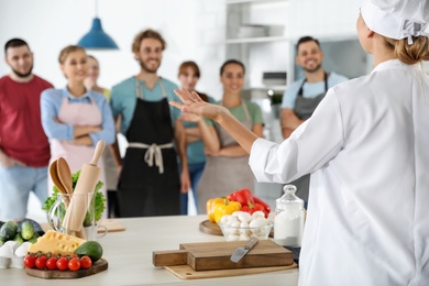 Photo of Group of people and female chef at cooking classes