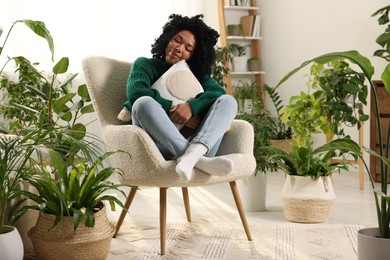 Woman relaxing surrounded by beautiful houseplants at home