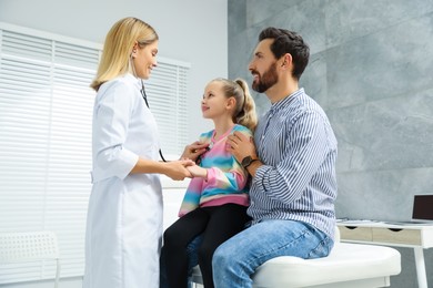Photo of Father and daughter having appointment with doctor in clinic