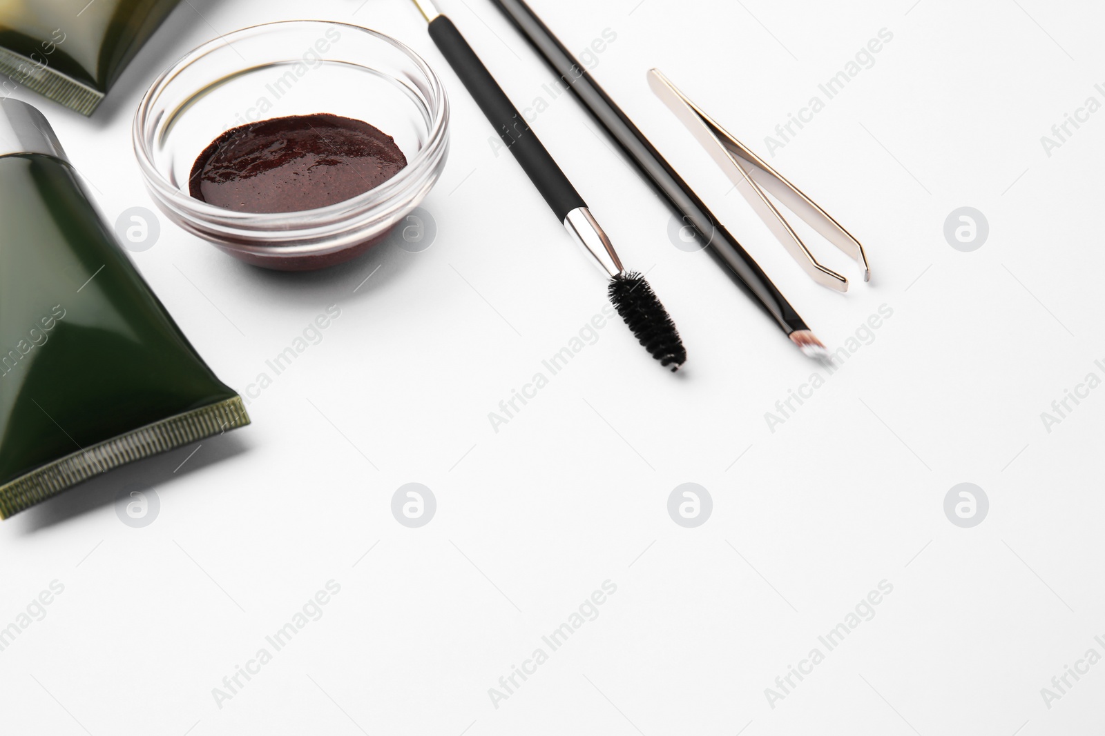 Photo of Eyebrow henna, professional tools and cosmetic products on white background, space for text