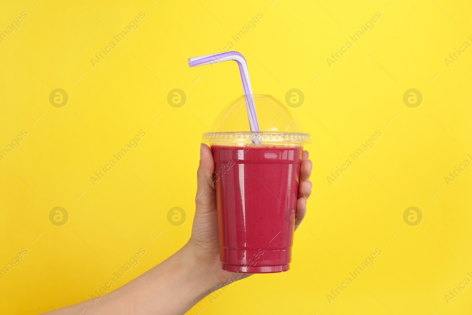 Photo of Woman holding plastic cup with delicious smoothie on color background