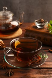Photo of Aromatic tea with anise stars and mint on wooden table
