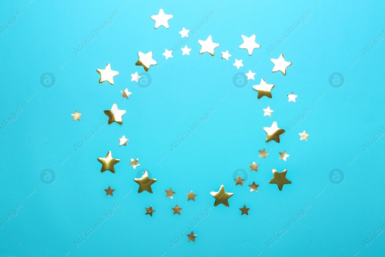 Photo of Frame made of confetti stars with space for text on blue background, top view. Christmas celebration