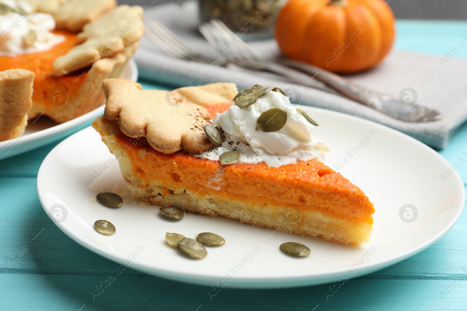 Photo of Slice of delicious homemade pumpkin pie on light blue wooden table, closeup