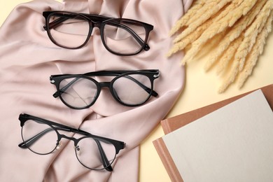 Flat lay composition with different stylish glasses on beige background