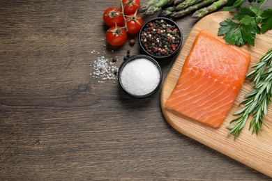 Photo of Fresh raw salmon and ingredients for marinade on wooden table, flat lay. Space for text