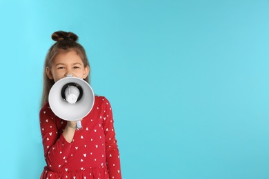 Cute funny girl with megaphone on color background. Space for text