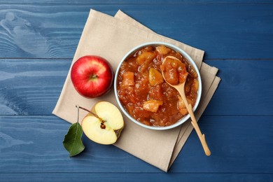 Photo of Tasty apple jam in bowl and fresh fruits on blue wooden table, top view
