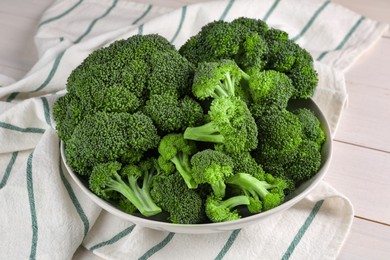 Photo of Bowl of fresh raw broccoli on white wooden table