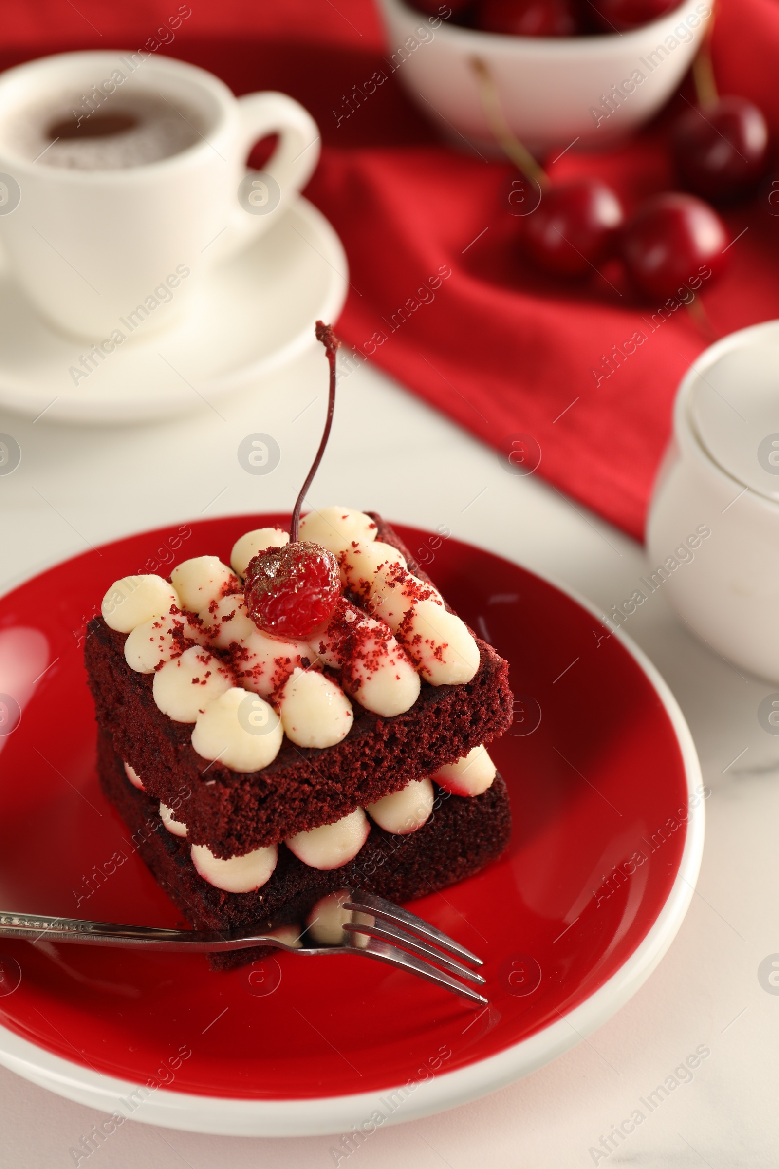 Photo of Piece of delicious red velvet cake and fork on white table, closeup