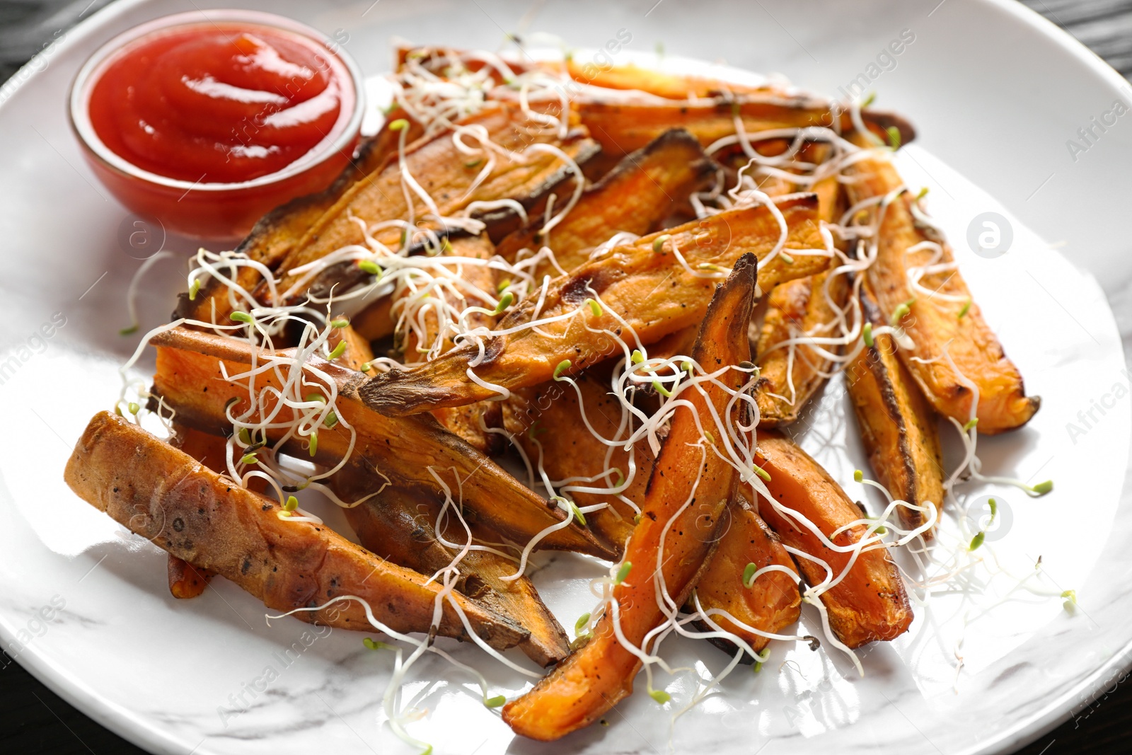 Photo of Tasty sweet potato fries on plate, closeup