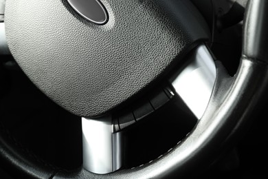 Photo of Black steering wheel as background, closeup view