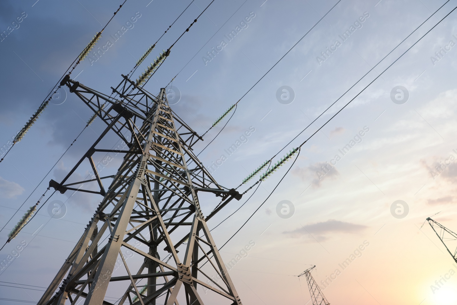 Photo of High voltage tower at sunset, low angle view