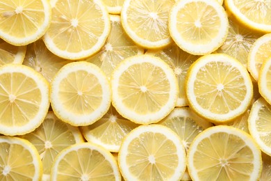 Slices of fresh lemons as background, top view