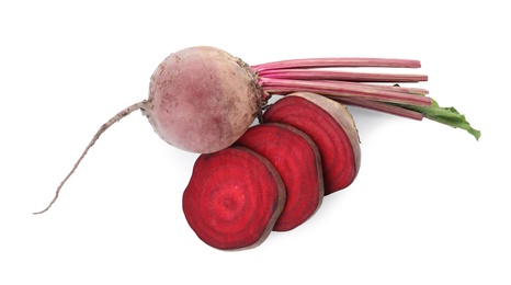 Whole and cut red beets on white background, top view