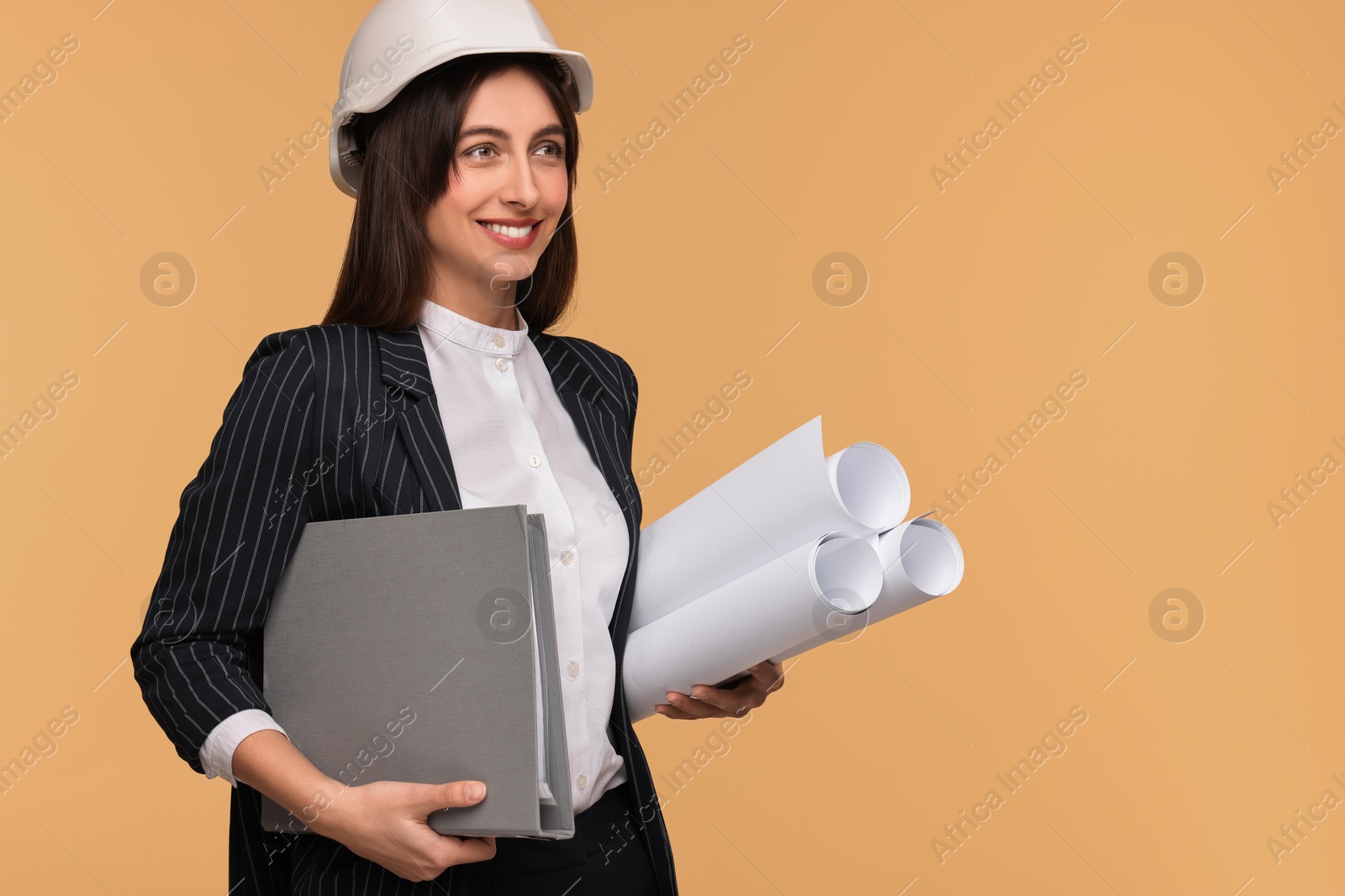 Photo of Architect in hard hat with drafts and folder on beige background, space for text