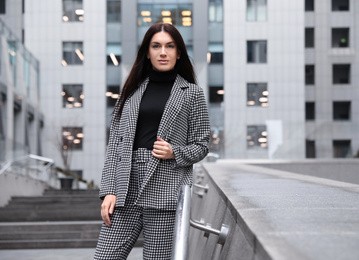 Photo of Portrait of beautiful woman in stylish suit on city street