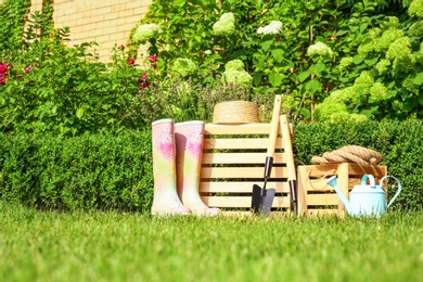 Photo of Wooden crates and gardening tools at backyard