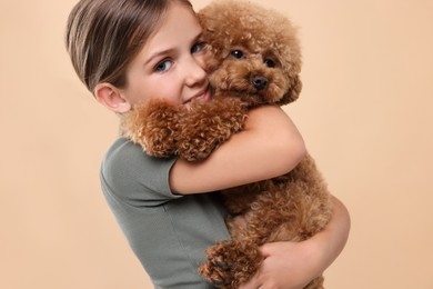 Little child with cute puppy on beige background. Lovely pet