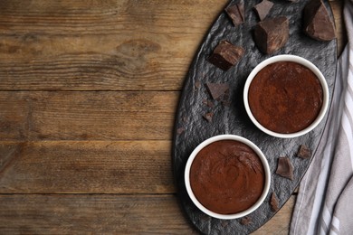 Photo of Delicious fresh fondant with chocolate chunks on wooden table, top view. Space for text