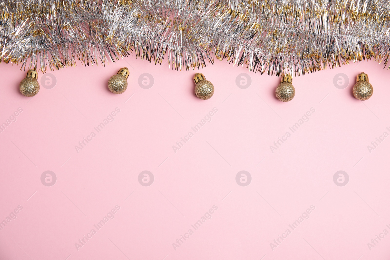 Photo of Sparkling tinsel and Christmas balls on pink background, flat lay. Space for text