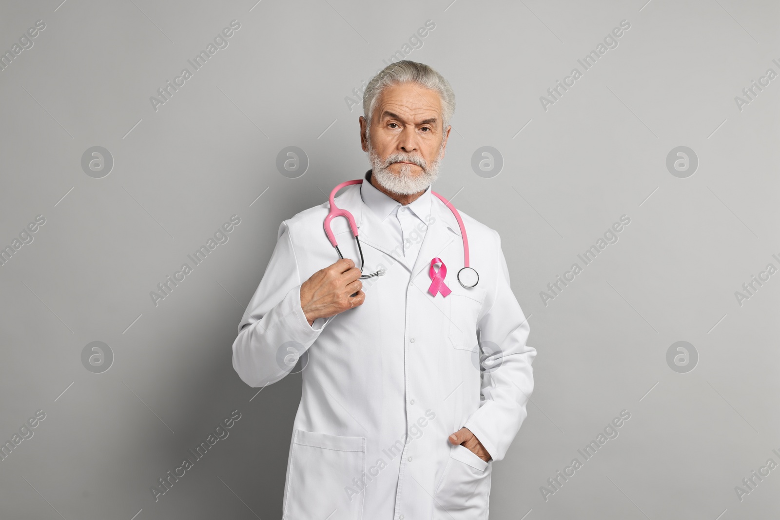 Photo of Mammologist with pink ribbon on gray background. Breast cancer awareness