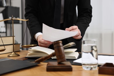 Lawyer working with document at wooden table, closeup