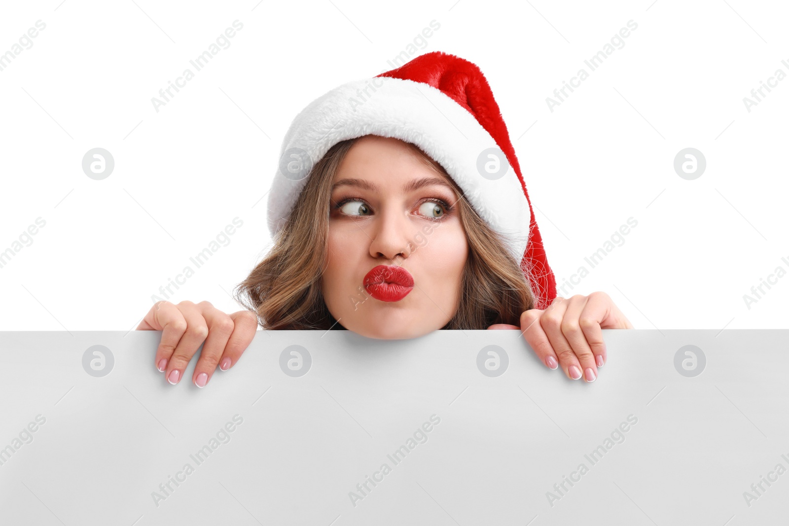 Photo of Beautiful Santa girl peeping out of blank banner on white background. Christmas celebration