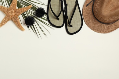 Photo of Flat lay composition with stylish beach accessories on light background, space for text