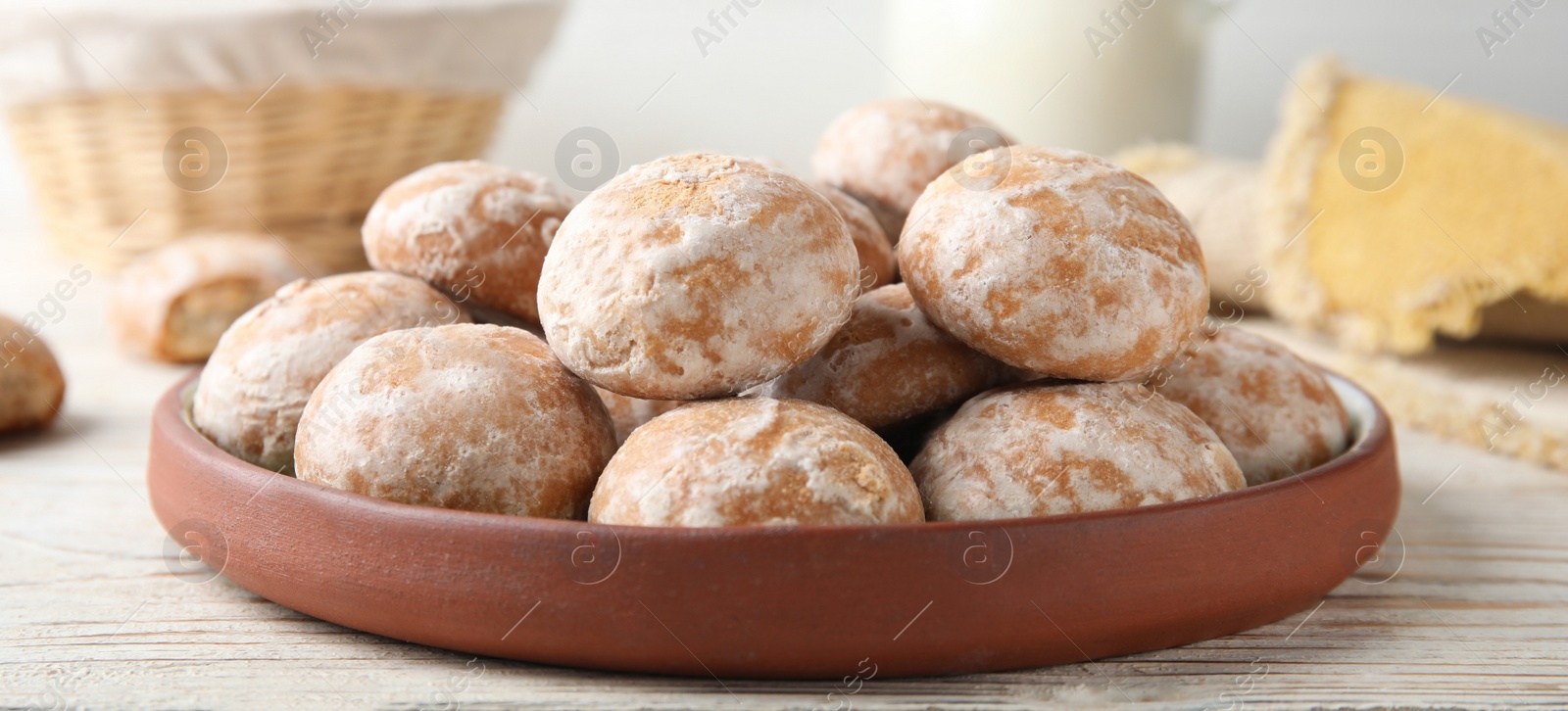 Image of Plate with tasty homemade gingerbread cookies on white wooden table, closeup. Banner design
